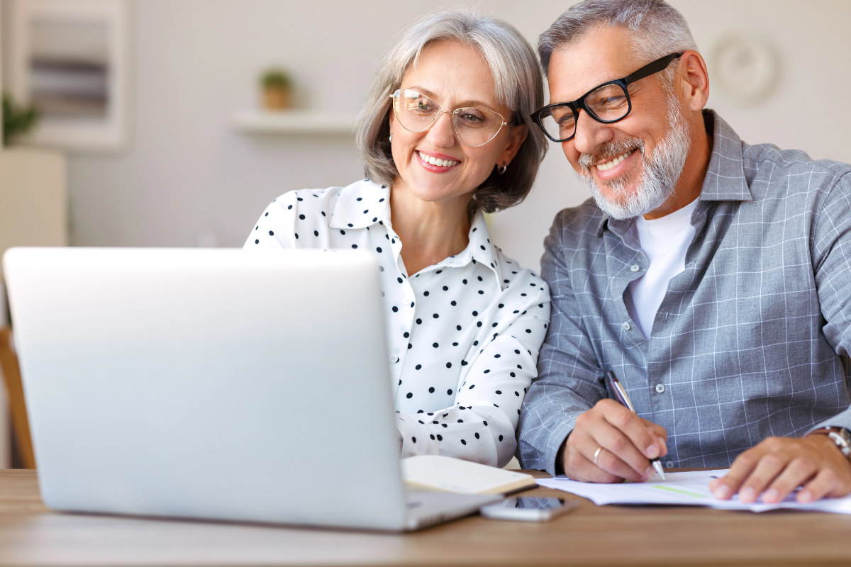 Smiling senior couple looking at a laptop while planning together